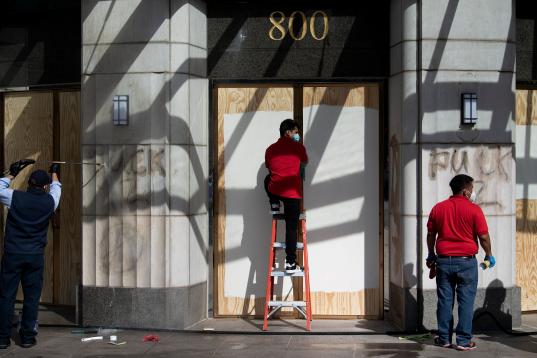 People remove graffiti near the White House after a third night of violent protests over the death of George Floyd on June 1, 2020, in Washington, DC. - Police fired tear gas outside the White House late Sunday as anti-racism protestors again to...