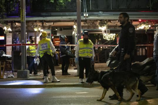 La policía y los sanitarios revisan la escena del ataque de Tel Aviv. 