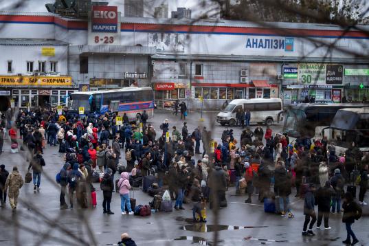 Ciudadanos ucranianos intentan coger un autobús para salir de Kiev. (AP Photo/Emilio Morenatti)