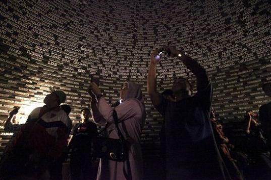 Varias personas fotografían los nombres de las víctimas del maremoto de 2004 en el Museo del Tsunami en Banda Aceh (Indonesia).