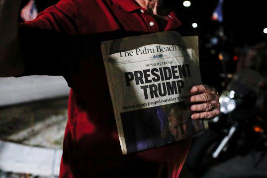 Un manifestante proTrump muestra un ejemplar de un periódico con el titular: 'Trump, presidente'.