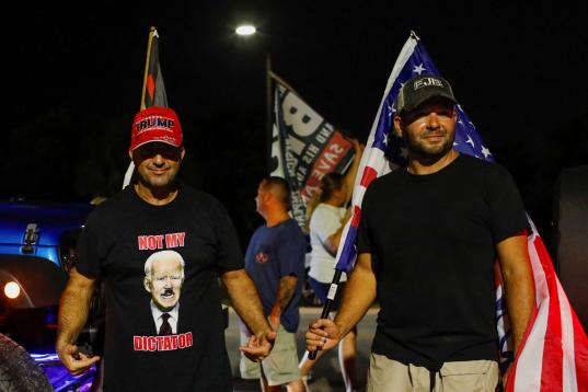 Seguidores de Trump, uno de ellos con una camiseta que retrata a Joe Biden como un dictador.