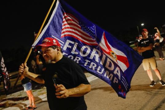 Un seguidor del expresidente muestra una pancarta en su apoyo desde Florida.