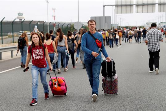 Los pasajeros de El Prat han tenido que llegar a la terminal andando maleta en mano por los accesos por carretera.