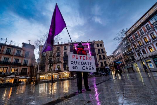 Una mujer sostiene una bandera feminista y una pancarta en la plaza de Zocodover, este lunes en Toledo, para conmemorar el Día Internacional de la Mujer.
