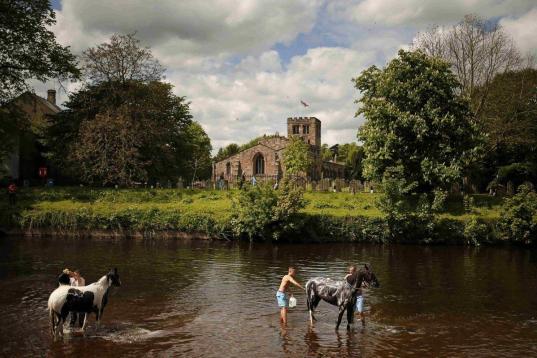 Viajeros lavan sus caballos en el río Eden en Appleby, Inglaterra. Forman parte de la feria anual de caballos que se lleva celebrando desde el año 1600. 