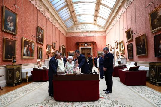 Los reyes de España observan una vitrina con objetos españoles en el palacio de Buckingham, a donde han llegado junto a Isabel II y el duque de Edimburgo.