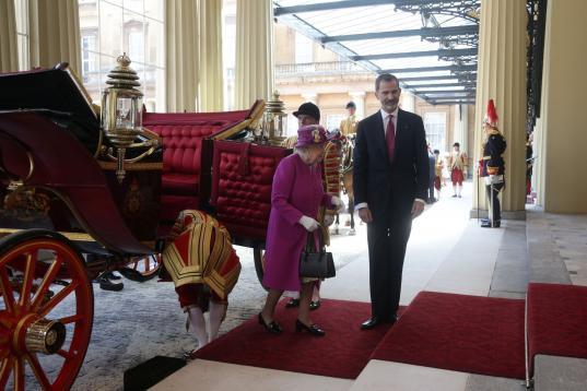 La reina Isabel II y el rey Felipe VI bajan del carruaje que les ha conducido hasta el palacio de Buckingham.