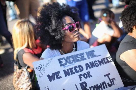Esta joven se manifiesta de forma pacífica con una pancarta en la que exige respuestas por la muerte de Michael Brown. 
