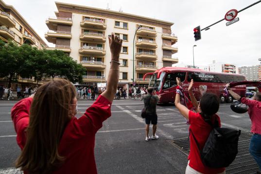 Aficionados del Sevilla reciben entre aplausos y gritos al autobús de su equipo