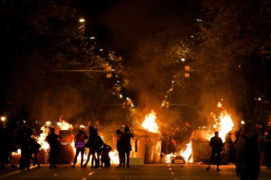 Protestors set fire to a barricade across a street during clashes with police in Barcelona, Spain, Wednesday, Oct. 16, 2019. Spain's government said Wednesday it would do whatever it takes to stamp out violence in Catalonia, where clashes betwee...
