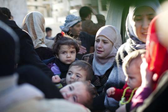 Una familia abandona su hogar tras el ataque de un tanque del ejército sirio en contra del edificio en Idlib, en el norte de Siria, el domingo 4 de marzo de 2012. La ONU revela que miles de refugiados han cruzado la frontera hacia el Líbano hu...