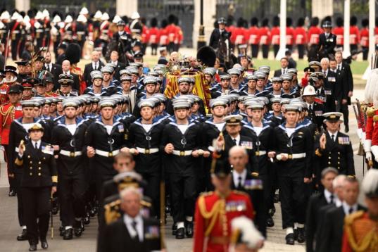 Los marineros de la Royal Navy tiran del ataúd de la reina Isabel II, envuelto en un estandarte real y en el carruaje de armas estatal de la Royal Navy.,