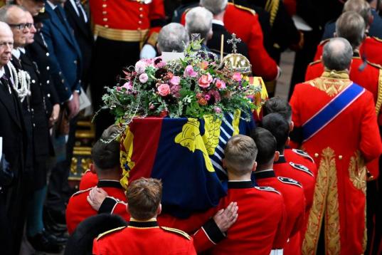 El féretro de la reina Isabel II se ha adornado con una corona de rosas rosas y rojas. Sobre ella, llama la atención un tarjetón con un mensaje manuscrito.