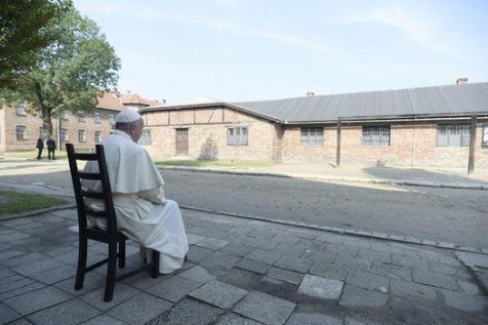 El papa Francisco sentado frente a un barracón durante su visita al campo de concentración nazi de Auschwitz.