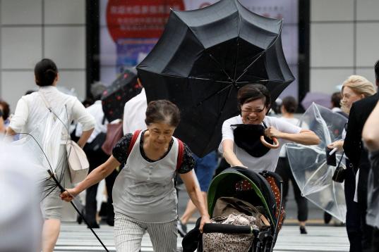 Peatones con sombrillas luchan contra los fuertes vientos y la lluvia en Tokio.