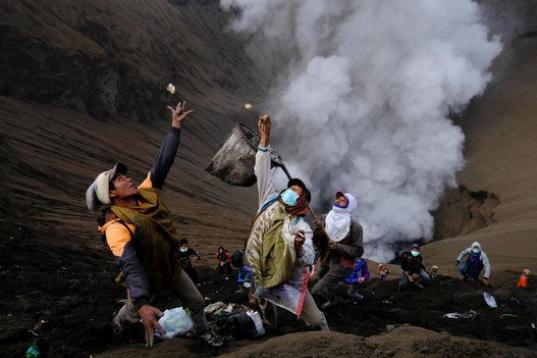 Un grupo de indonesios recogen monedas que les lanza la tribu Tengger durante el Yadnya Kasada, en el Monte Bromo, Indonesia.