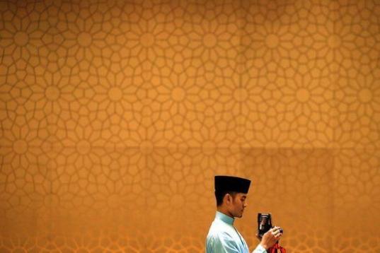 Un joven realiza una fotografía durante un evento al que asiste el primer ministro malasio, Najib Razak, en Kuala Lumpur, Malasia. 