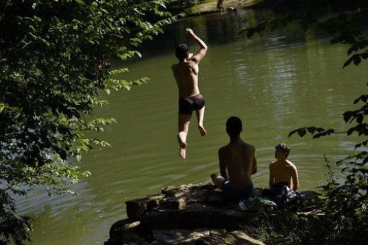 La gente se relaja y se refresca de las altas temperaturas en el río Arga, en Pamplona, donde están alcanzando los 40º.