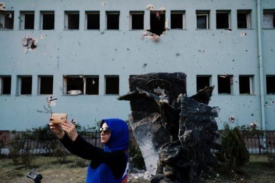 Una mujer se toma un selfie frente a lo que queda del edificio de las Fuerzas Especiales de Policía en la ciudad de Ankara, después de haber sido bombardeado durante el fallido golpe de estado en Turquía. 

