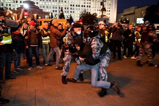 Dos policías reducen a un joven contrario a la última decisión de Putin