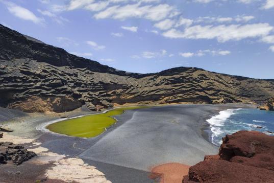 Al suroeste de la canaria isla de Lanzarote se encuentra el charco de los Clicos, también llamado el Lago Verde debido al color de sus aguas, fruto de su entorno volcánico. El azul del agua del mar, la playa negra y el lago verde forman un con...