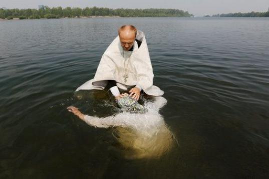 Un sacerdote ortodoxo bautiza a una mujer en el río Yenisei durante una ceremonia que marca la cristianización del país, en Siberia, Rusia. 