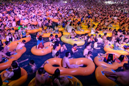 Un grupo de bañistas se refresca mientras asiste a una actuación en una piscina de Wuhan, en la provincia china de Hubei.