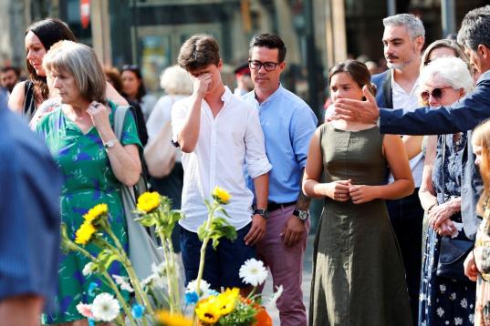 Los familiares de las víctimas mortales del atentado del 17 de agosto del año pasado en Barcelona y Cambrils (Tarragona) han protagonizado esta mañana una sobria y emocionada ofrenda floral.