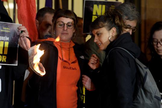City councillor of Barcelona's city hall and member of radical left-wing Catalan independentist political party CUP (Popular Unity Candidates) Maria Robira (R) and CUP's deputy Mireia Vehi burn a picture of Spain's King during an anti-monarchy d...