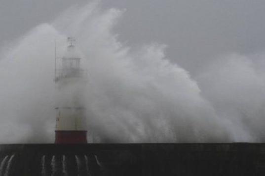 Las olas rompen sobre el puerto y el faro de Newhaven, al sur de Inglaterra. 