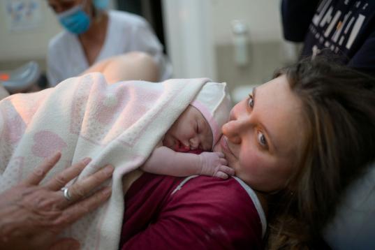 Aleina abraza a su bebé, Snizhana, tras dar a luz en la maternidad de Mykolaiv.