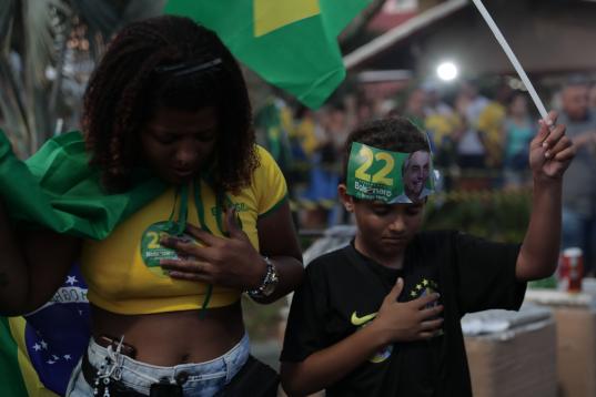 Ciudadanos brasileños bolsonaristas rezan mientras se sucede el conteo de votos.
