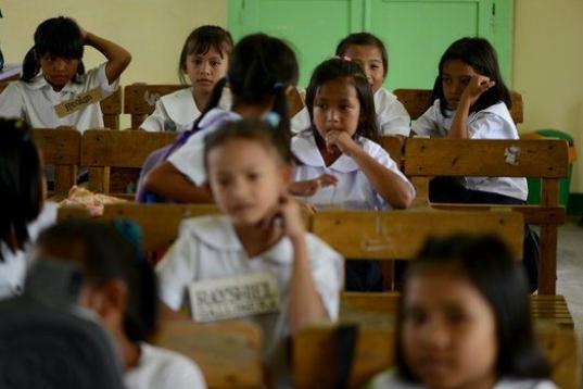 Genesis Tuazon (al fondo a la derecha), de ocho años, está sentada en su clase de la escuela de Panghulo, cerca del Artex Compound en Malabon (Filipinas) el 5 de junio de 2013. 