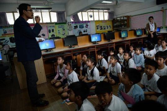 Chamaya Pamutito, de 7 años, escucha a un profesor en la sala de ordenadores de su escuela de Bangkok, en junio de 2013. 