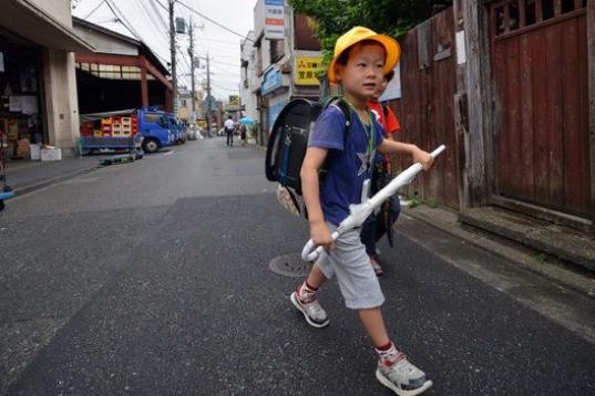 El estudiante de primaria Seishi Nishida, de seis años, camina hacia su colegio en Tokio, el 11 de junio de 2013.