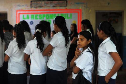 Silvia Alvarado (segunda de la derecha) hace fila en el Centro Escolar Bernd Grabs en El Salvador, el 1 de julio de 2013.