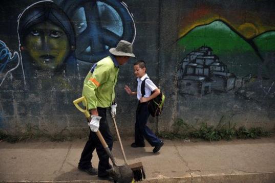 El costarricense Gerald Sequeira, de 8 años, saluda al barrendero mientras se dirige al colegio, el 22 de agosto de 2013.