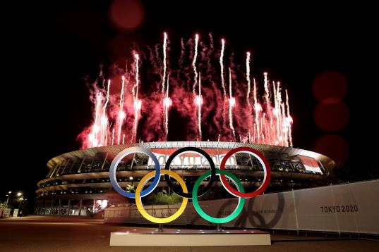 Imagen del exterior de la ceremonia de apertura con los fuegos artificiales y los aros olímpicos de Tokio 2020.