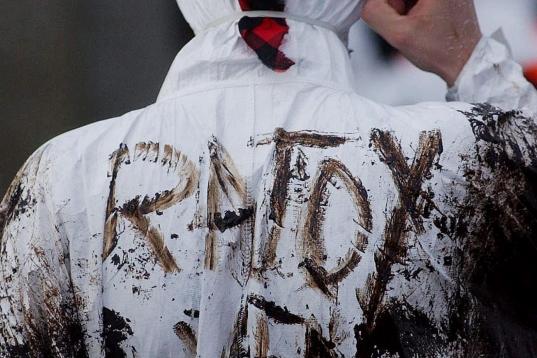 Un voluntario con el siguiente mensaje escrito con fuel en su espalda: "Rajoy, ven".