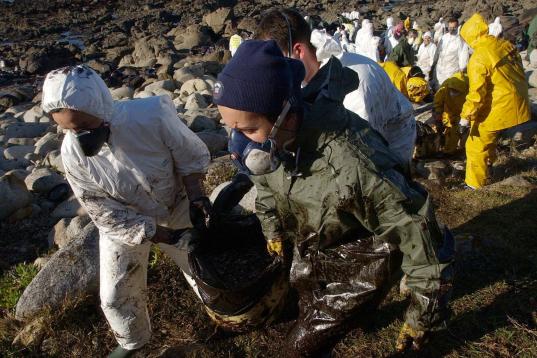 Some of hundreds of volunteers coming from all over of Spain clean the beaches between Oia and Bayona, northwestern Spain, 06 December 2002. Portugal beefed up its anti-pollution measures 05 December as oil slicks from the sunken tanker Prestige...