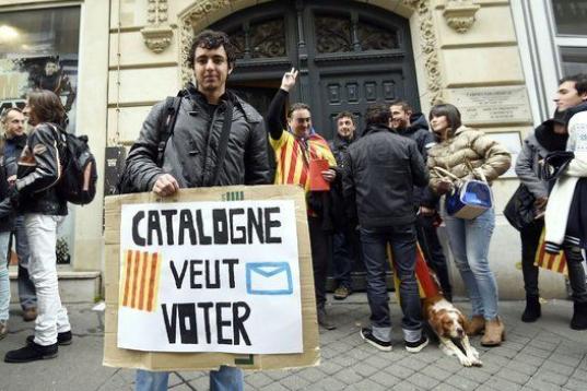 Un joven muestra una pancarta que reza "Cataluña quiere votar" a las afueras de la Delegación del Gobierno catalán en Francia.