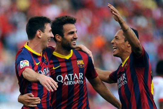 Barcelona's Argentinian forward Lionel Messi (L) celebrates with his teammates after scoring during the Spanish league football match UD Almeria vs FC Barcelona at the Juegos Mediterraneos stadium in Almeria on September 28, 2013.   AFP PHOTO/ J...