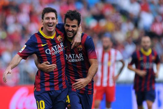 Barcelona's Argentinian forward Lionel Messi (L) celebrates with midfielder Cesc Fabregas after scoring during the Spanish league football match UD Almeria vs FC Barcelona at the Juegos Mediterraneos stadium in Almeria on September 28, 2013.   A...