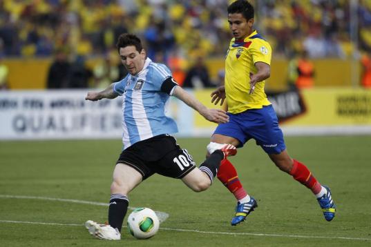 Argentina's Lionel Messi, left, kicks the ball next t Ecuador's Fernando Saritama during a 2014 World Cup qualifying soccer match in Quito, Ecuador, Tuesday, June 11, 2013. (AP Photo/Dolores Ochoa).