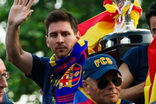 BARCELONA, SPAIN - MAY 13:  Lionel Messi of FC Barcelona celebrates with team-mates on an open top bus during their victory parade after winning the Spanish Liga title on May 13, 2013 in Barcelona, Spain.  (Photo by David Ramos/Getty Images)