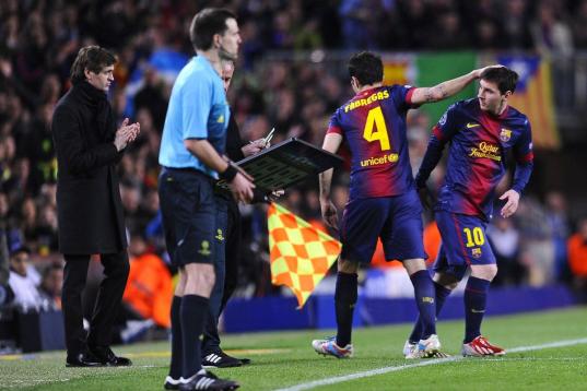 Barcelona's Lionel Messi, from Argentina, right, looks at Barcelona's head coach Francesc 'Tito' Vilanova, left, as he replaces Barcelona's Cesc Fabregas during the Champions League quarterfinal second leg soccer match between FC Barcelona and P...