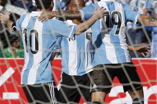 Argentina's Ever Banega, right, celebrates with his teammates Clemente Rodriguez, center, and Lionel Messi, after Ever scored a goal against Bolivia during a 2014 World Cup qualifying soccer game in La Paz, Bolivia, Tuesday, March 26, 2013. (AP ...