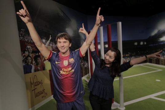A visitor poses with the wax figure of Lionel Messi at the Madame Tussauds exhibition in Tokyo, Wednesday, March 13, 2013.(AP Photo/Itsuo Inouye)
