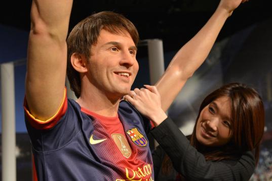 A Japanese woman inspects the wax figure of football star Lionel Messi at a press preview of Madame Tussauds museum in Tokyo on March 13, 2013. Tokyo's Madame Tussauds museum will exhibit some 60 wax figures of Japanese and foreign stars when it...